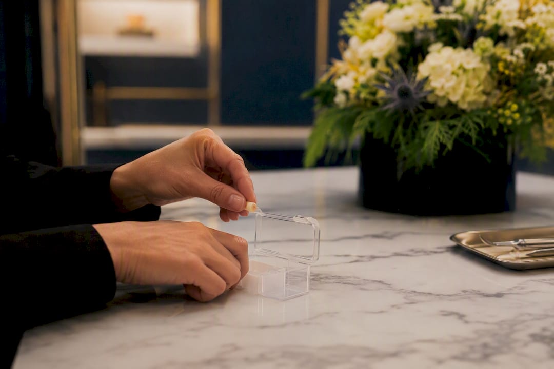 Hands placing temporary crown in pill box